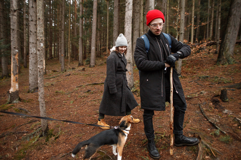 Couple walking dog in forest 